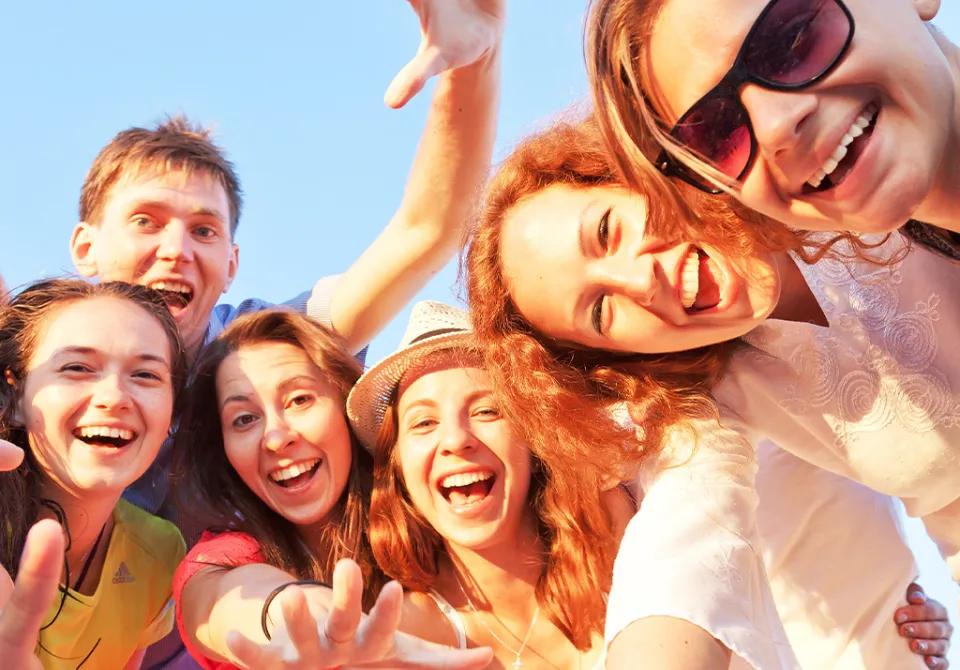Teenagers reaching out toward camera
