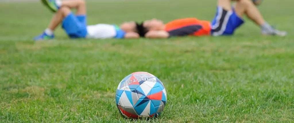 Boys laying won a football pitch
