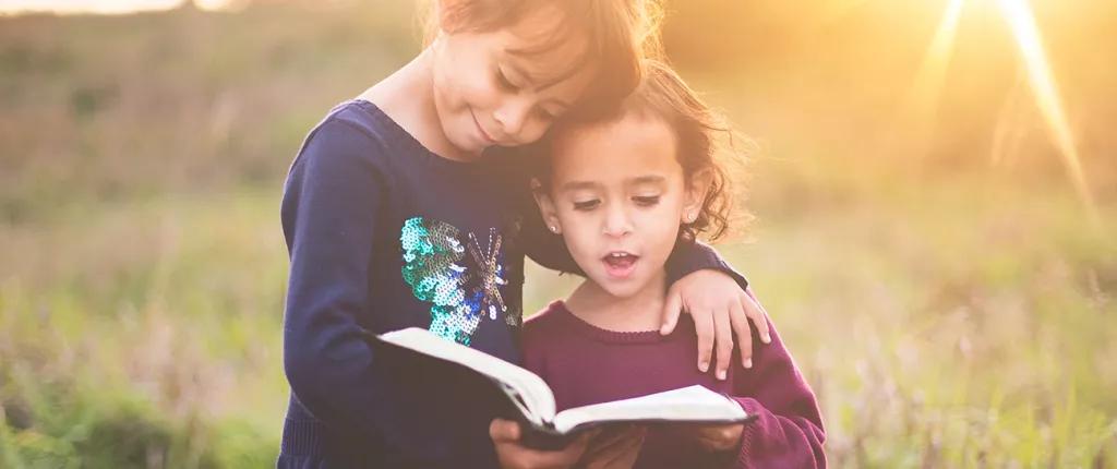 Two girls reading a book