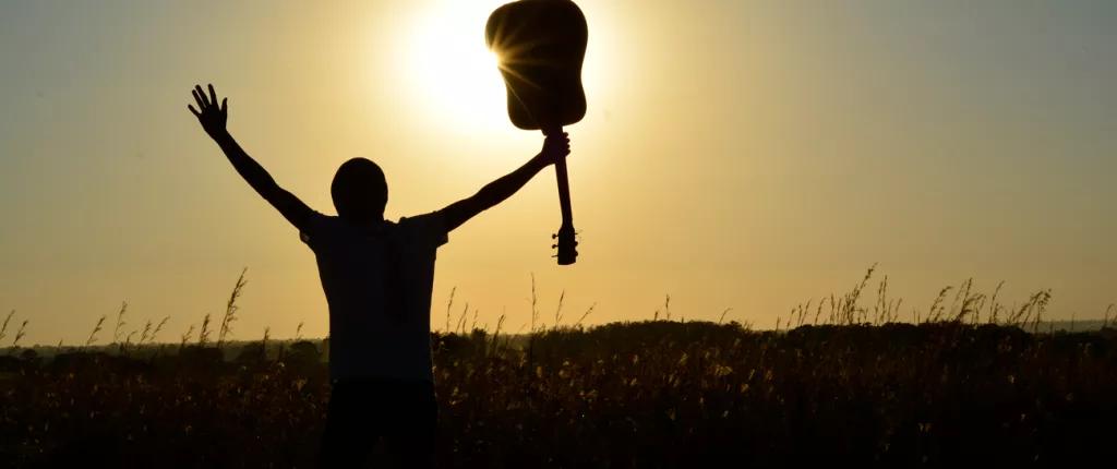 Teenager with his guitar aloft
