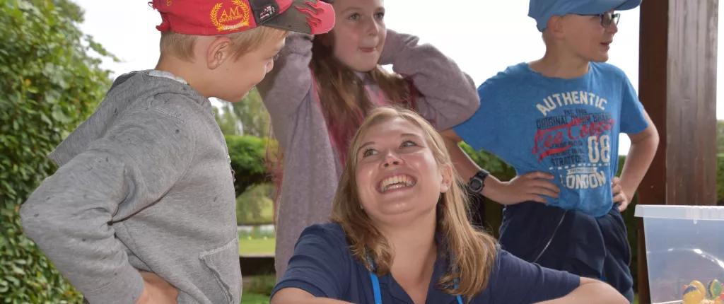 Volunteer laughs as children have fun