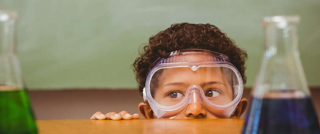 Boy in safety goggles with science equipment