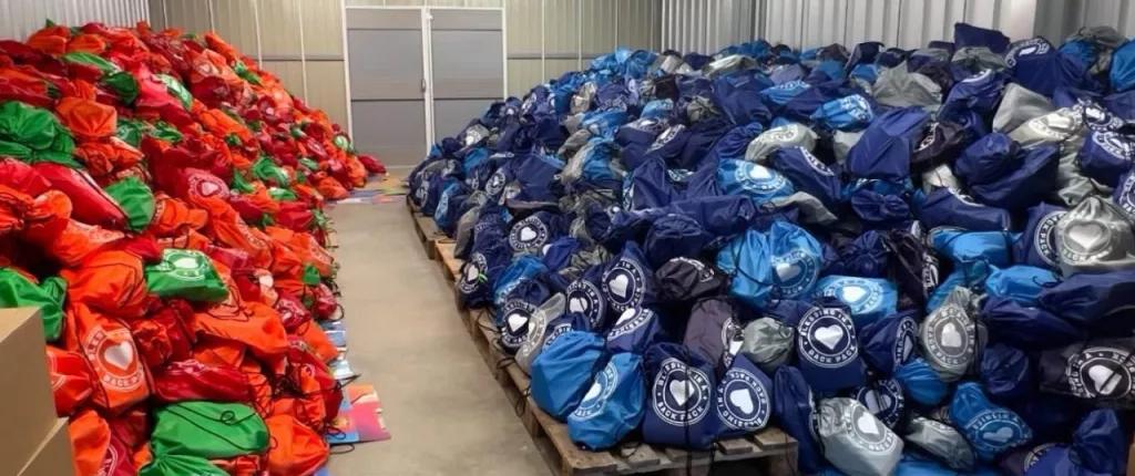 Piles of filled backpacks in a warehouse