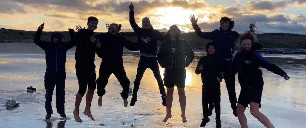 Group pf young people jumping on the beach