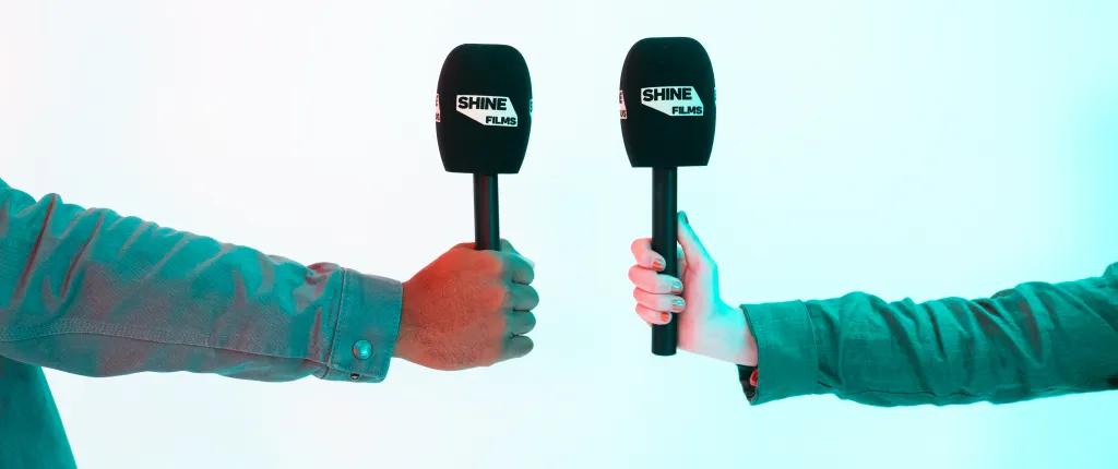 2 hands holding microphones