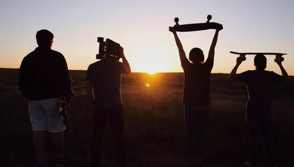 Holding up skateboards to the sunset