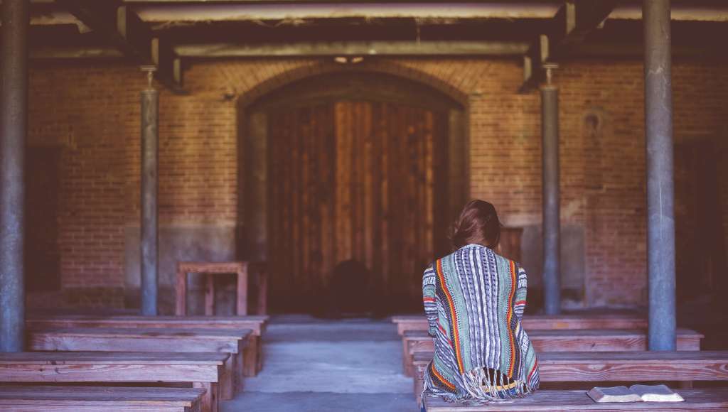 Woman praying church bench