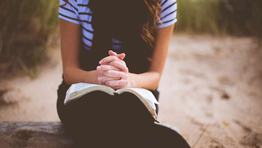 Woman praying sand dunes