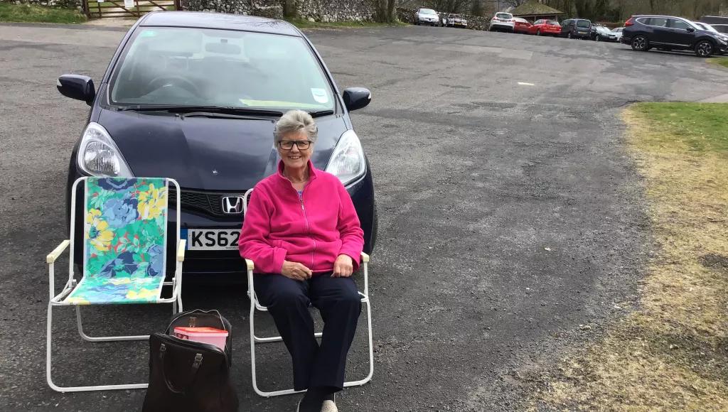 lady in chair by car
