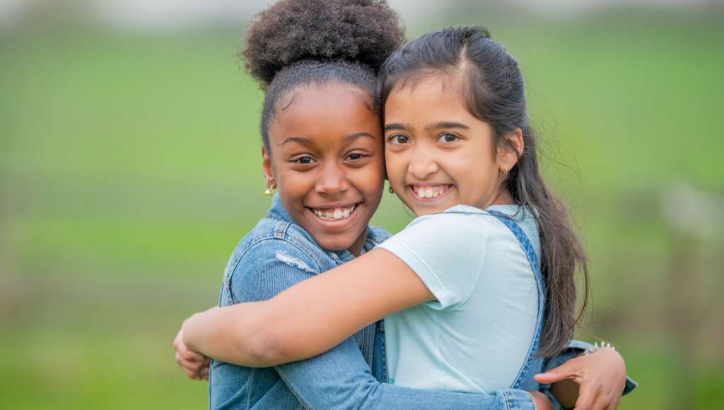 Two young girls hugging