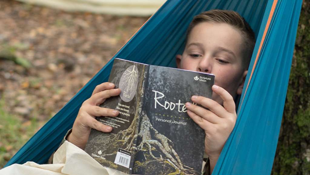 Boy reading the Rooted journal