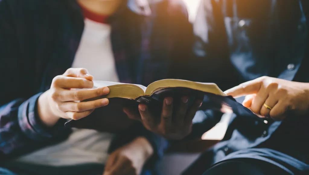 Two young people reading the bible