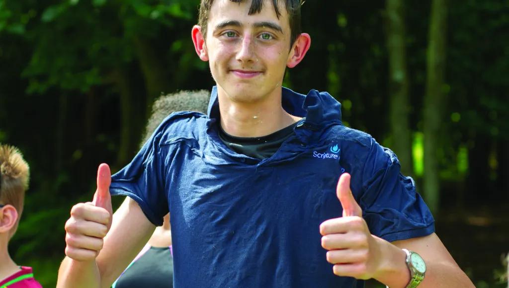 A young leader in a blue t-shirt after a water fight