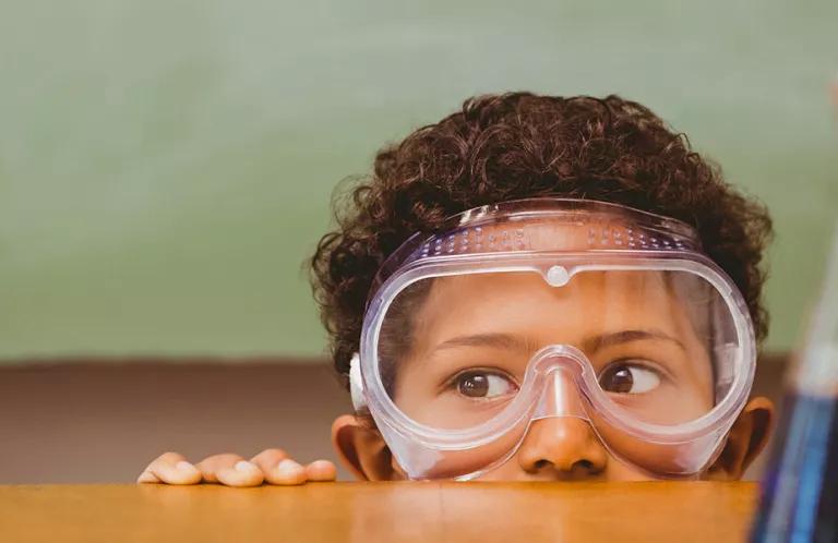 Boy in safety goggles with science equipment