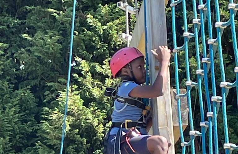 Child on climbing wall at Launchpad 2022