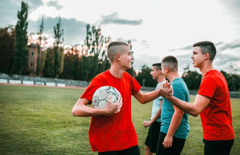 Teenage boys football high five