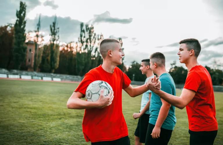 Teenage boys football high five