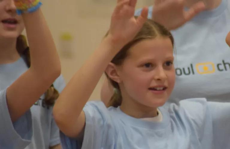 Young girl singing as part of large choir