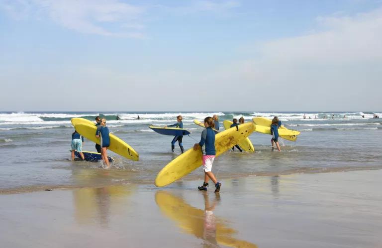Kids with surfboards on Cornish beach
