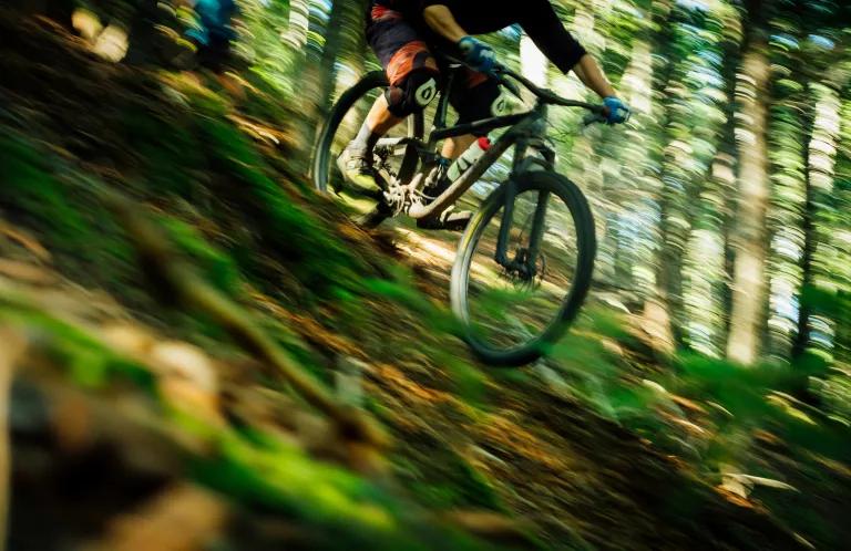 Mountain biker racing down a slope