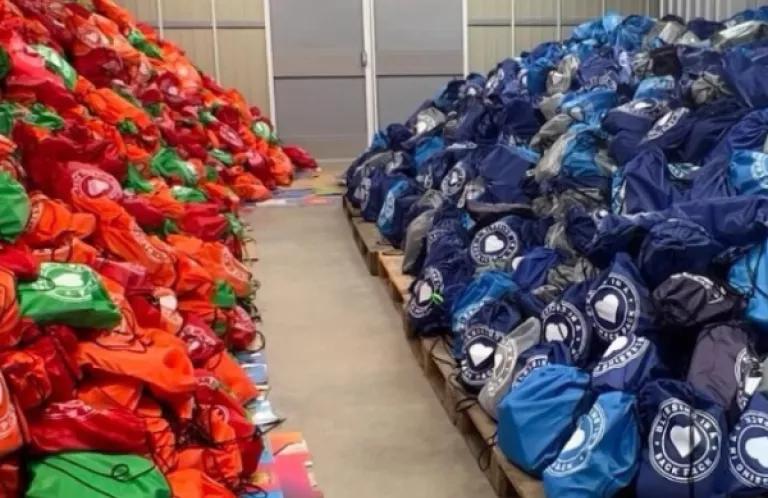 Piles of filled backpacks in a warehouse