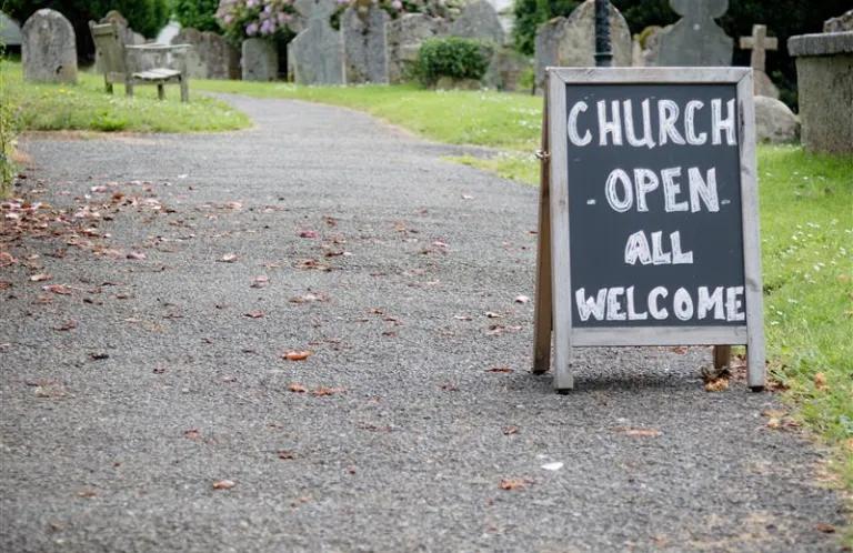 Sign outside church building saying: Church open. all wecome