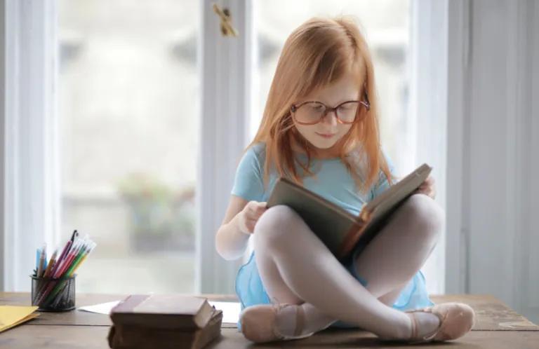 Child sat on table reading