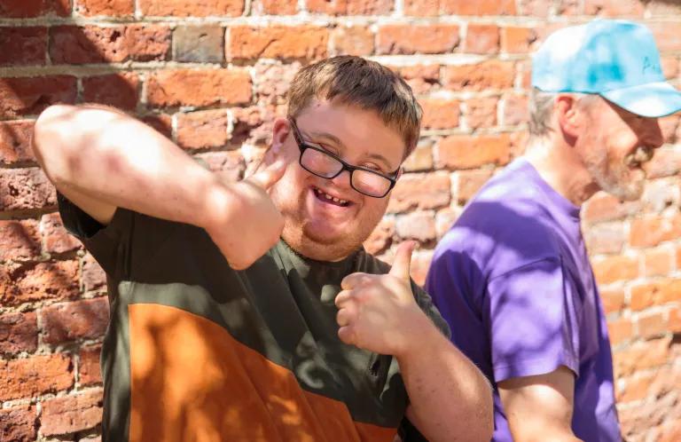 A young man gives thumbs up