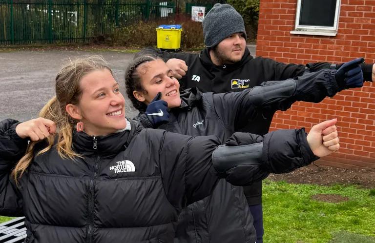 3 young people practise an archery pose
