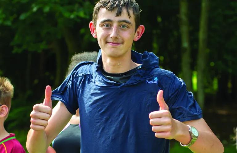 A young leader in a blue t-shirt after a water fight