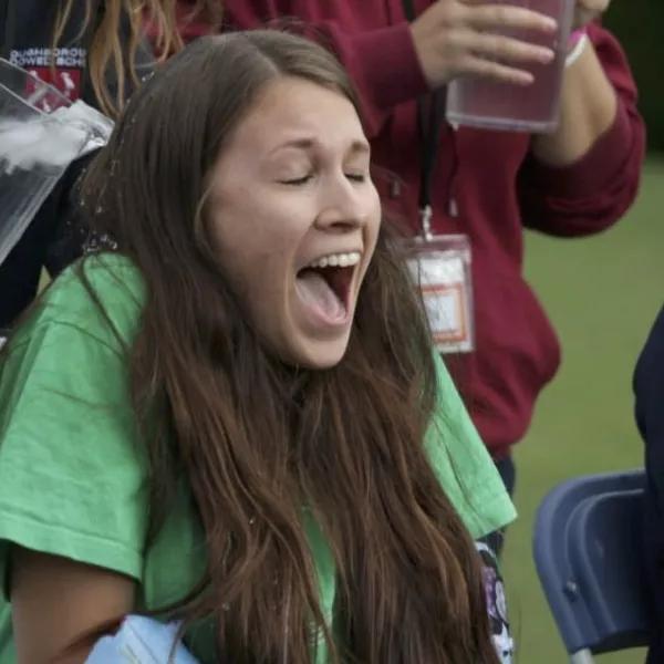 Girl having ice poured on her back