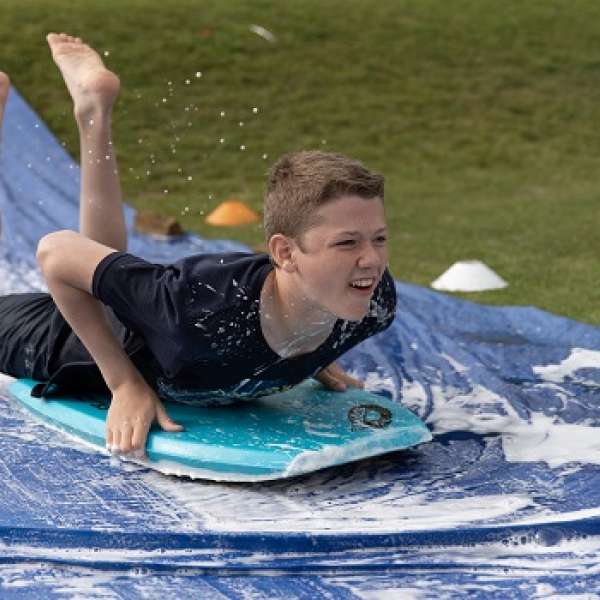 Young man taking the plunge on the water slide