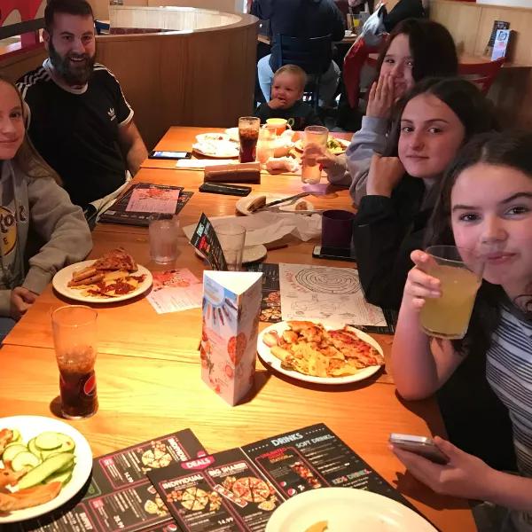 group of teenagers sitting around a table at a restaurant