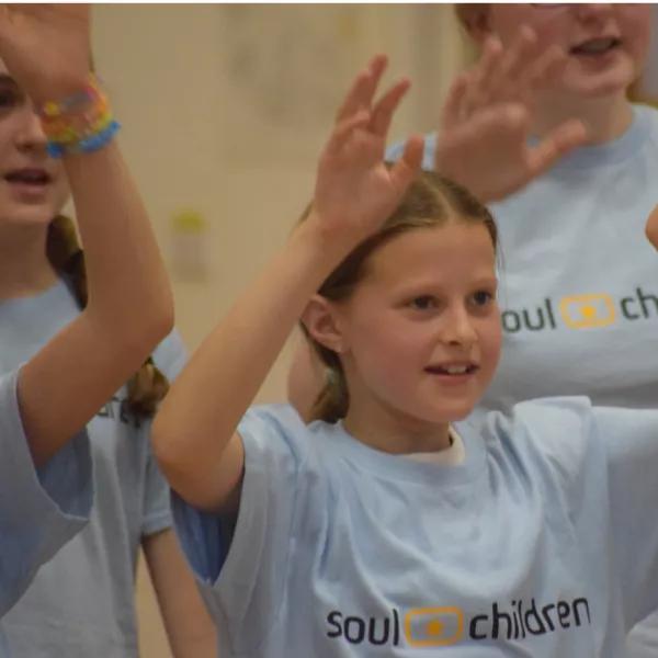 Young girl singing as part of large choir