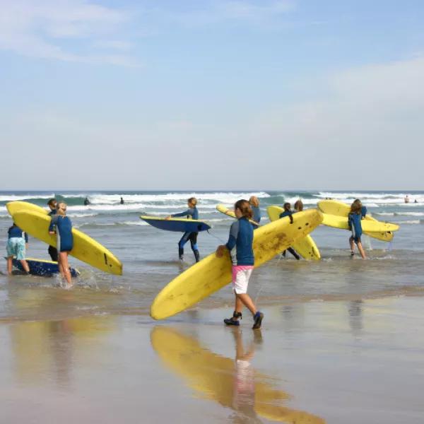Kids with surfboards on Cornish beach