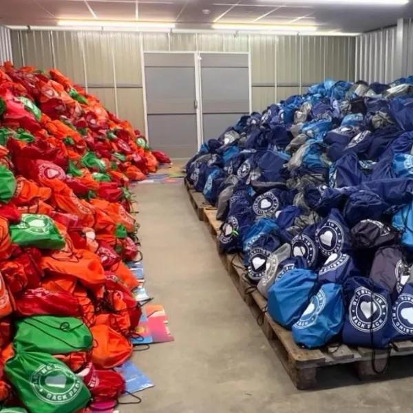 Piles of filled backpacks in a warehouse