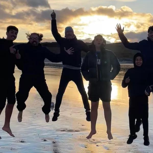 Group pf young people jumping on the beach