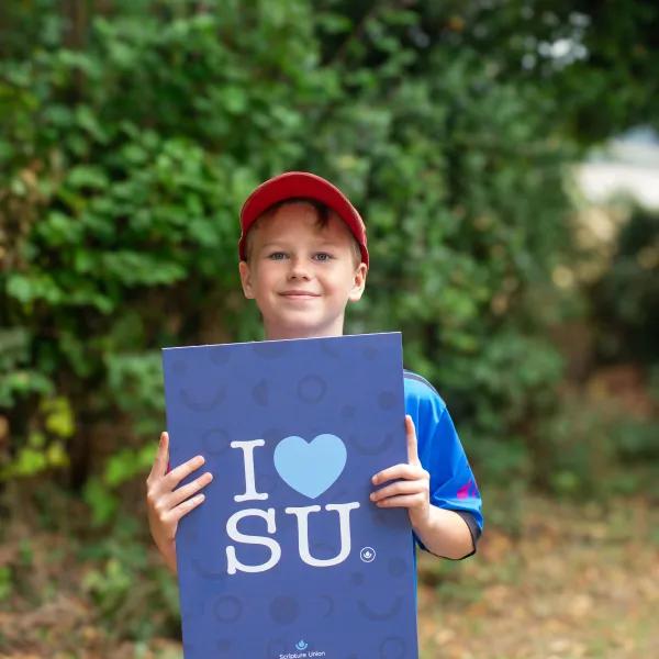 Child holding I love SU poster
