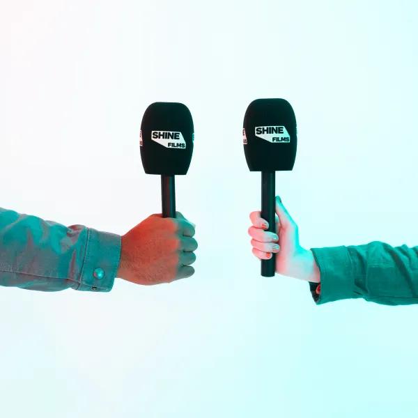 2 hands holding microphones