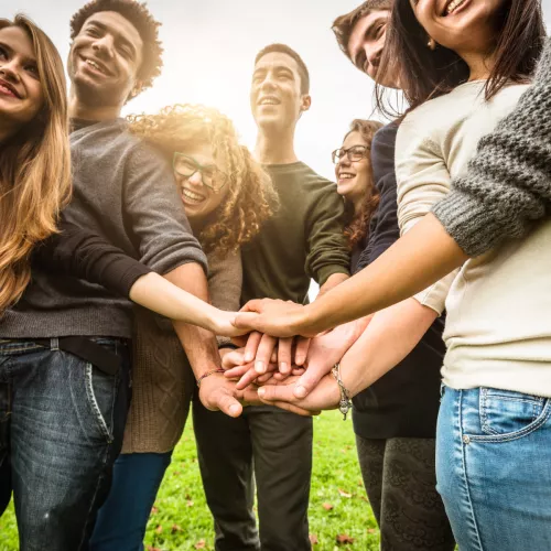 teenagers with hands on top of each others