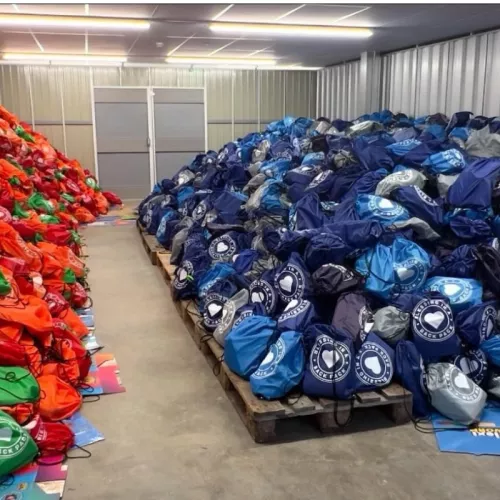 Piles of filled backpacks in a warehouse