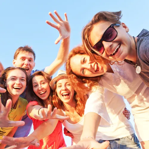 Happy young people waving hands at the camera